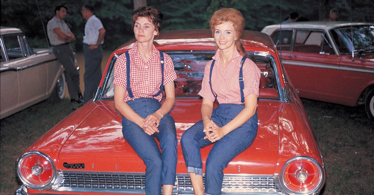 Donna and Roni Stoneman sit on top of a red vehicle in matching outfits