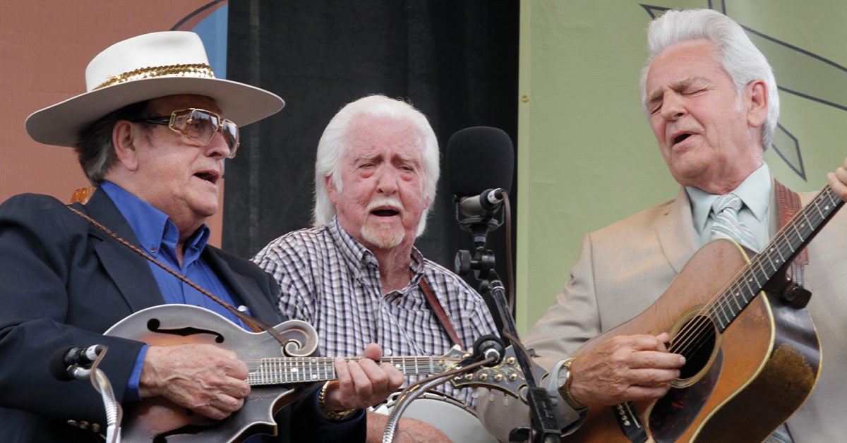 Bobby Osborne, JD Crowe, and Del McCoury singing and playing their instruments together on stage