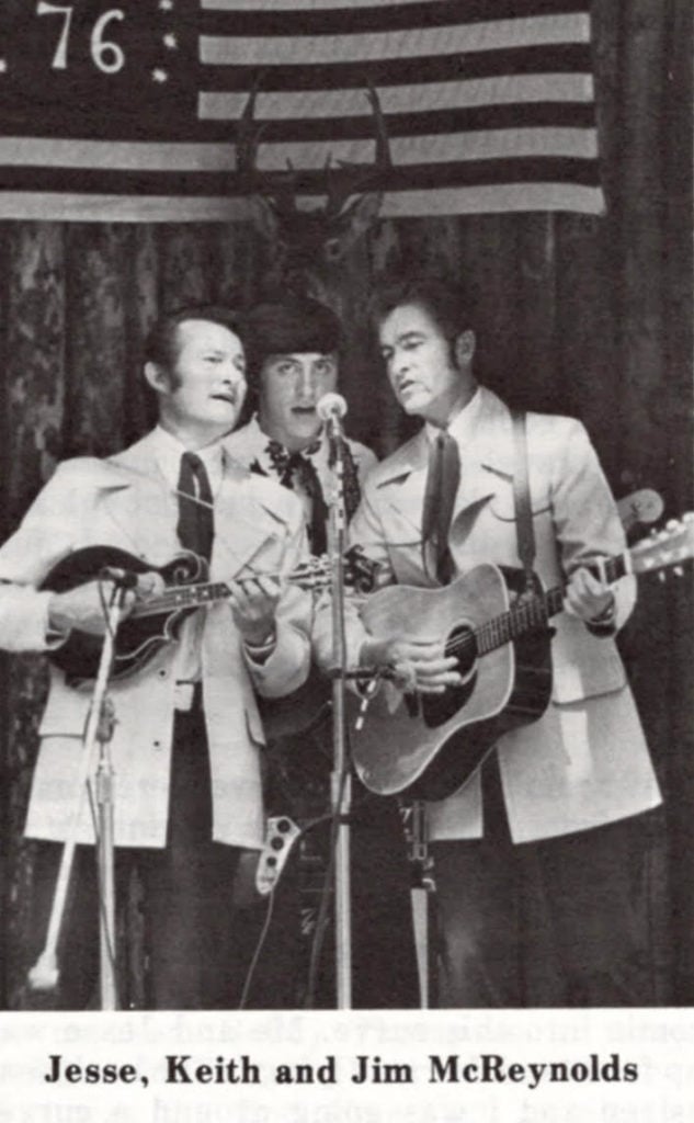 Black and white image of Jesse, Keith, and Jim McReynolds performing on stage.