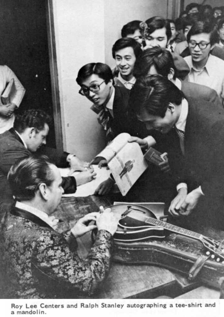 Roy Lee Centers and Ralph Stanley autographing a tee-shirt and a mandolin.